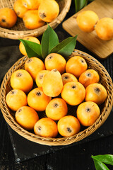 Fresh Loquat Fruits in Woven Baskets with Green Leaves on Rustic Wooden Background