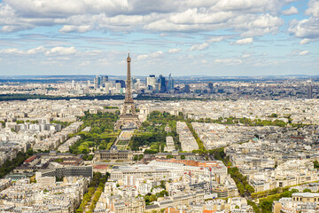 A panoramic view of the city of Paris in France, taken from the top of the Montparnasse skyscraper The Eiffel Tower and many other landmarks are visible. The sky is blue and cloudy