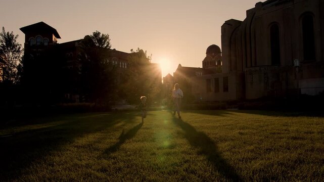A mother and son are running forward at sunset a very beautiful shot that symbolizes the unity between mother and son.