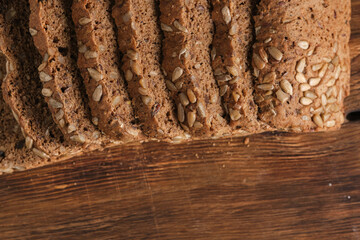 Whole grain bread with sunflower seeds on wooden board.