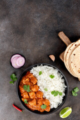 Indian butter chicken with basmati rice, roti or chapatti on gray background. Top view. Copy space. 