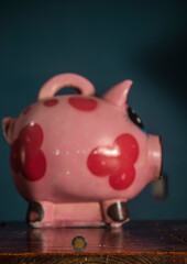 moneda mexicana adelante de una gran alcancía de cerdo rosado