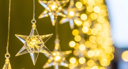 Sparkling crystal star ornaments hanging with soft yellow bokeh lights