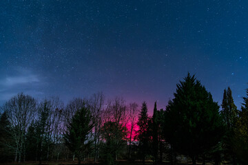 Fototapeta premium Star filled night sky illuminated by the bright magentas of the Aurora Borealis over the Dordogne region of France