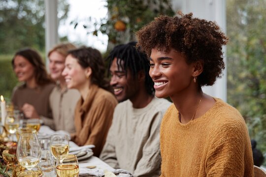 Friends and family enjoying a festive gathering at a warm dinner table - Powered by Adobe