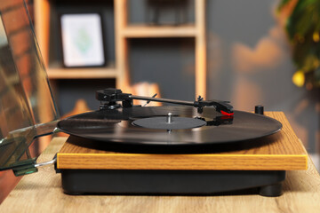 Modern turntable with vinyl record at home