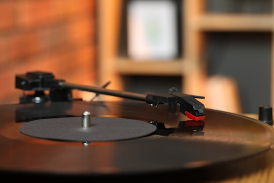 Modern turntable with vinyl record at home, closeup. Space for text