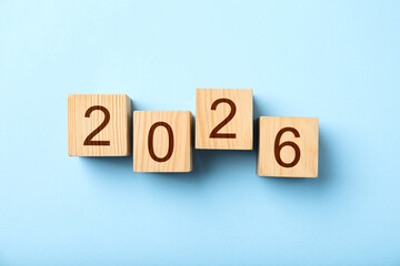 Obraz premium New 2026 year. Cubes with numbers on light blue background, top view