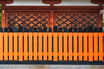Traditional orange and black wooden fence lattice design in Kyoto shrine