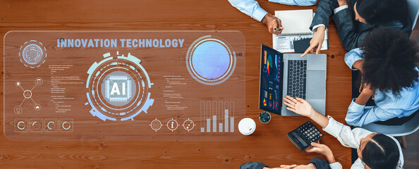 A top-down view of a professional team collaborating on artificial intelligence innovation, featuring data visualization and strategic planning in a modern office environment. Trope