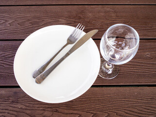 white plate with knife and fork and empty glass