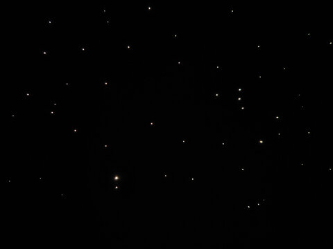 Glowing golden dust particles suspended in the air against a black background, abstract gold glitter lights background. de-focused