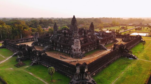 Aerial view of the angkor wat temple complex in siem reap, cambodia. Golden sunrise light illuminates the ancient khmer architecture and surrounding jungle. UNESCO World Heritage Site