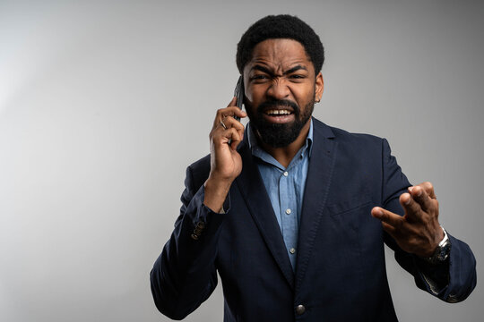 Angry black businessman making phone call on isolated background