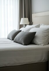 A close-up view of soft pillows and warm white duvet covers on a large, comfortable bed in a bright, modern bedroom, suggesting relaxation and sleep ,white ,minimal ,indoors