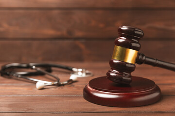 A stethoscope and hammer on a desk. Medical malpractice, personal injury lawyer, and healthcare legal aspects concept.Lawyer.Legal definition of medical negligence. Law concept.Healthcare and Medicine