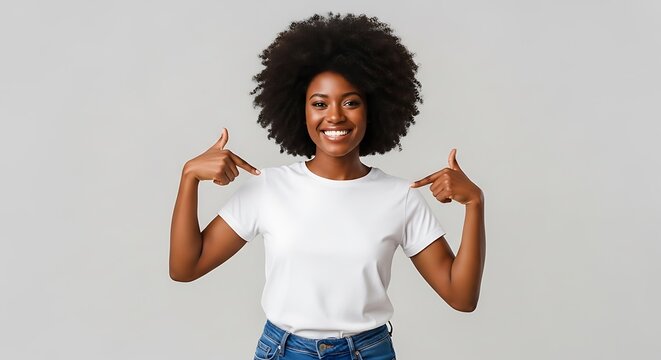 A smiling black woman with an afro pointing to her plain white tshirt