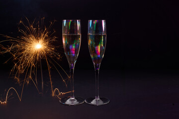 Sparkling Celebration. Two champagne glasses with bright sparklers against a dark background