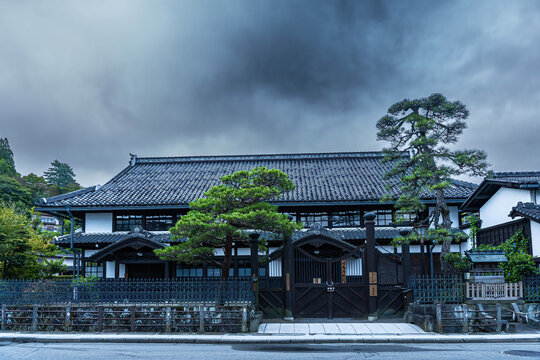 View of a traditional Japanese building with dark wooden elements under a cloudy sky, exuding a sense of history and tranquility, Takayama, Gifu, Japan.