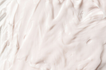 Smooth creamy texture in soft light creates a delicate abstract surface for cosmetic or skincare product background.