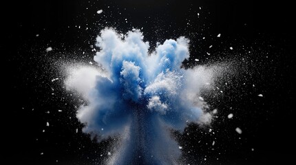 Explosion of blue and white powder particles frozen in motion against a dark background.