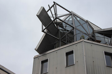 Modern architectural structure featuring a unique angular design with glass and metal elements, showcasing innovative construction techniques and contemporary aesthetics in urban environment