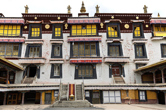 View of the Potala Palace reveals intricate details, bold colors, and traditional architecture against the backdrop of a clear sky, Lhasa, China.