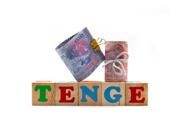 The word "TENGE" and banknotes of 5,000 and 10,000 Kazakhstani tenge on a white background