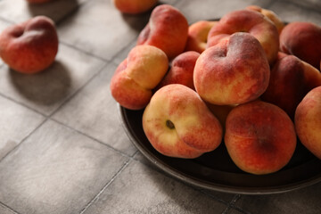 Plate with sweet fig peaches on grey tile background