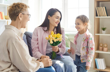 Grandmother and daughter celebrate women day, birthday or mother day with mother by gifting bouquet of flowers at home, creating happy family moment with love and togetherness and affection.