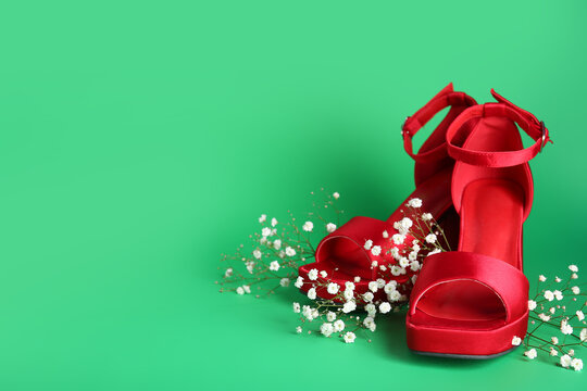 Red ankle straps shoes with gypsophila on green background - Powered by Adobe