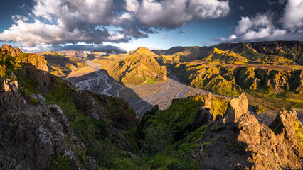 Fototapeta premium Beautiful sunset in the lush valley of Þórsmörk (Thorsmork) in Iceland’s southern highlands — a dramatic landscape of moss-covered mountains, glacial rivers