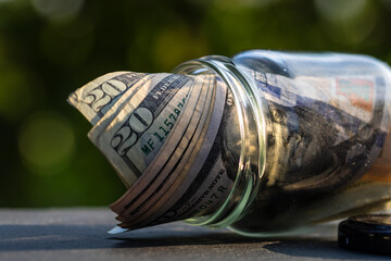 US dollar banknote saving money in glass jar. Consumption and economy