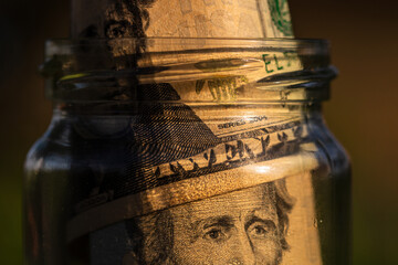 US dollar banknote saving money in glass jar. Consumption and economy