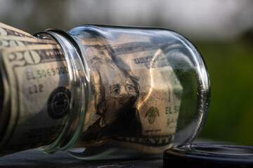 US dollar banknote saving money in glass jar. Consumption and economy