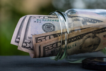 US dollar banknote saving money in glass jar. Consumption and economy