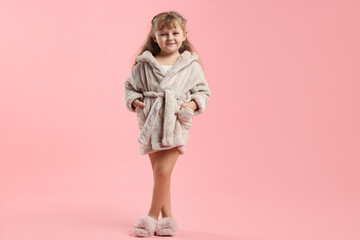 Cute girl in bathrobe on pink background. Space for text