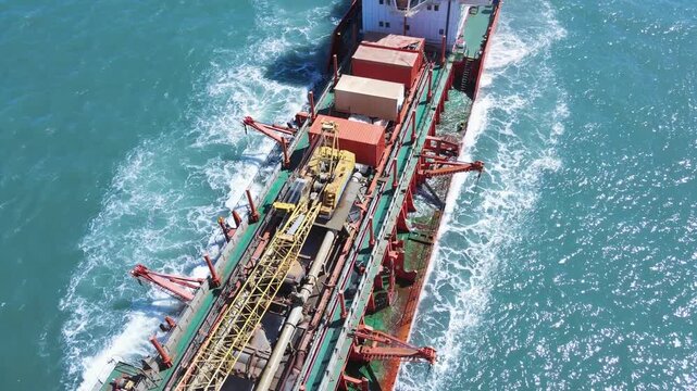 Aerial scene suction dredger ship sailing at sea, showing equipment and machinery used in large-scale dredging operations.