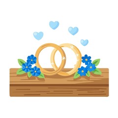 Close-up view of golden wedding rings and beautiful small blue flowers on wooden tabletop