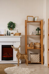 Fototapeta premium Modern fireplace with Christmas decorations in interior of living room