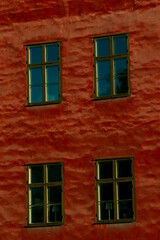 Textured red facade with wooden-framed windows in Sweden