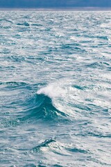 Blue ocean surface with small breaking wave
