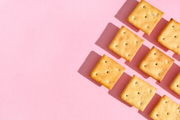 Composition with tasty crackers on pink background, closeup