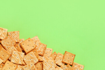 Composition with tasty crackers on green background, closeup