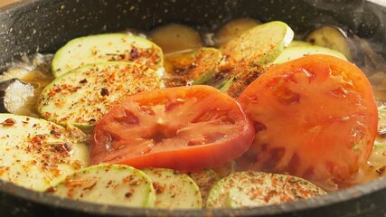 Onions, peppers, eggplant, zucchini, and tomatoes are fried in a pan with spices - Powered by Adobe