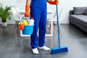 Professional cleaner with cleaning supplies ready to sanitize a home or office
