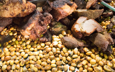 Close up of Chicharrones, traditional Peruvian fried pork belly, served with toasted corn (cancha serrana). Authentic food from the Andes region of Peru. Crispy and savory dish.