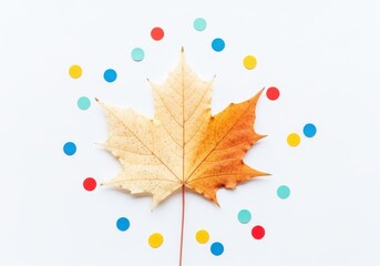 A single maple leaf with two distinct colorations, yellow and orange, surrounded by colorful confetti on a white background