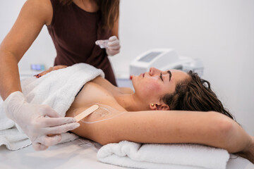Woman preparing for laser hair removal treatment armpit in beauty clinic