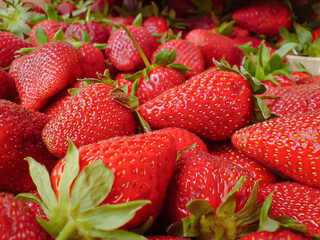 Freshly picked strawberries with green tails on market